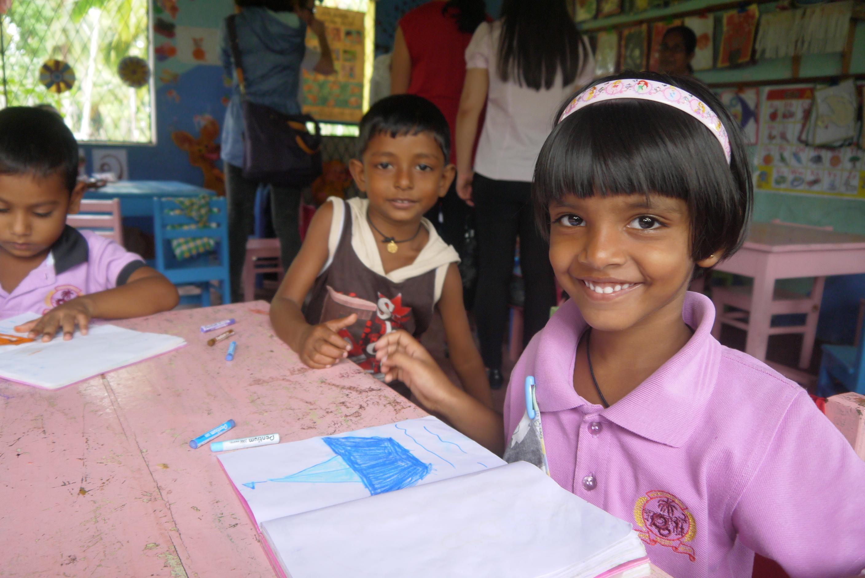 Students complete their classwork while a Projects Abroad volunteer is teaching an English class in Sri Lanka Children smile at the camera while doing their homework at our volunteer teaching placements in Sri Lanka